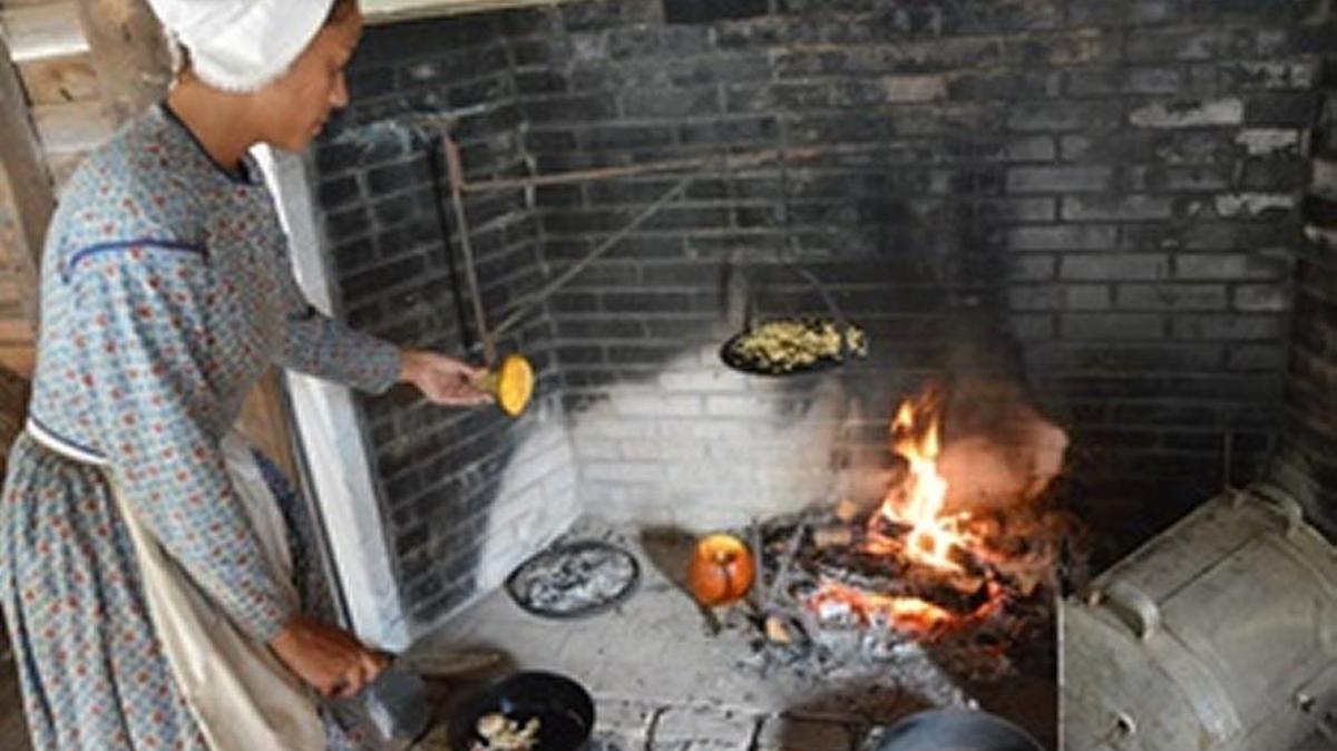 Historic Brattonsville interpreter cooks over an open hearth. It’s one of the on-going activities at “By Way of the Back Door,” each Saturday in February at the site in McConnells