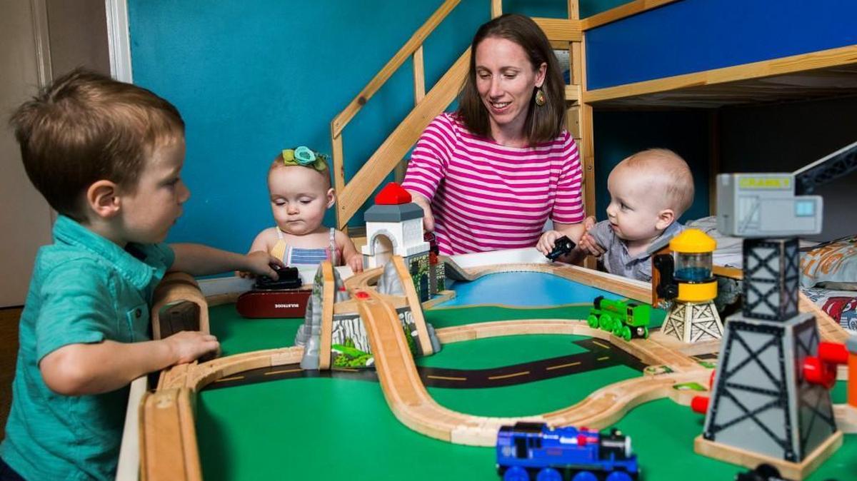 
Christy Trabun and her children, from left, Gage, 3, Shiloh, 10 months, and Coen, 10 months, play with a toy train set in their Dallas home. The Trabuns used a national program called Snowflake to “adopt” unused embryos of an Oregon couple who had conceived children through in-vitro fertilization. Cade Trabun, 4, Coen and Shiloh were conceived as a result of the donated embryos. 
