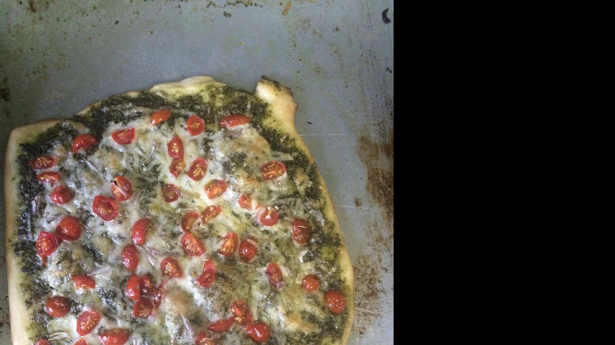 
Basil Pesto Pizza with Cheese and Grape Tomatoes.

