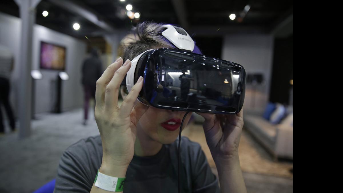 
A woman demonstrates the Oculus virtual reality headset at the Facebook F8 Developers Conference in San Francisco. Once seen as mainly a tool for alien-blasting video gamers, now major movie studios, television producers and even budding artists are adopting the technology that has users donning bulky goggles, entering house-sized domes, even rigging their smartphones to immerse themselves in faraway realms. 
