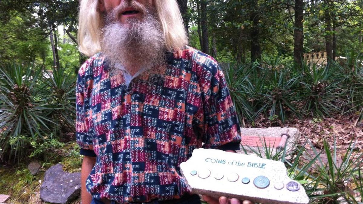 Don Bradley shows examples of coins mentioned in the Bible at Palestine Gardens in Lucedale, Miss.