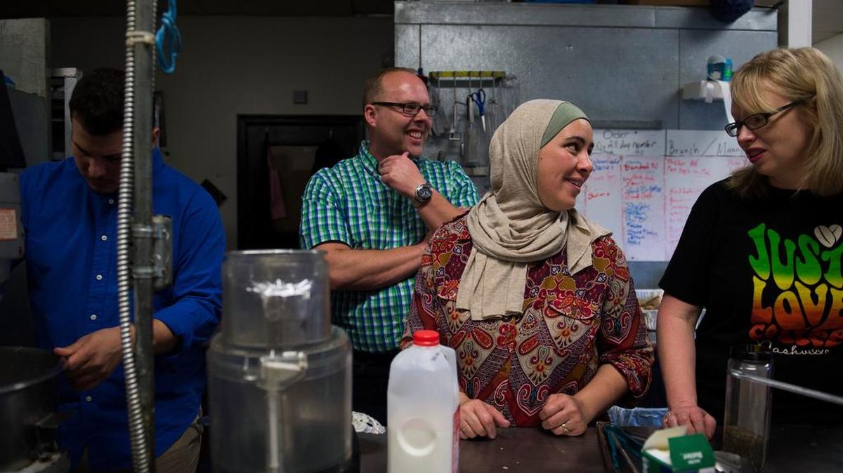 Annan Chamdin, Brian Mumpower, Hiba Kattih and Stephanie Mumpower, from left, chat while preparing meals for a Thanksgiving Day Murfreesboro Muslim Youth event.