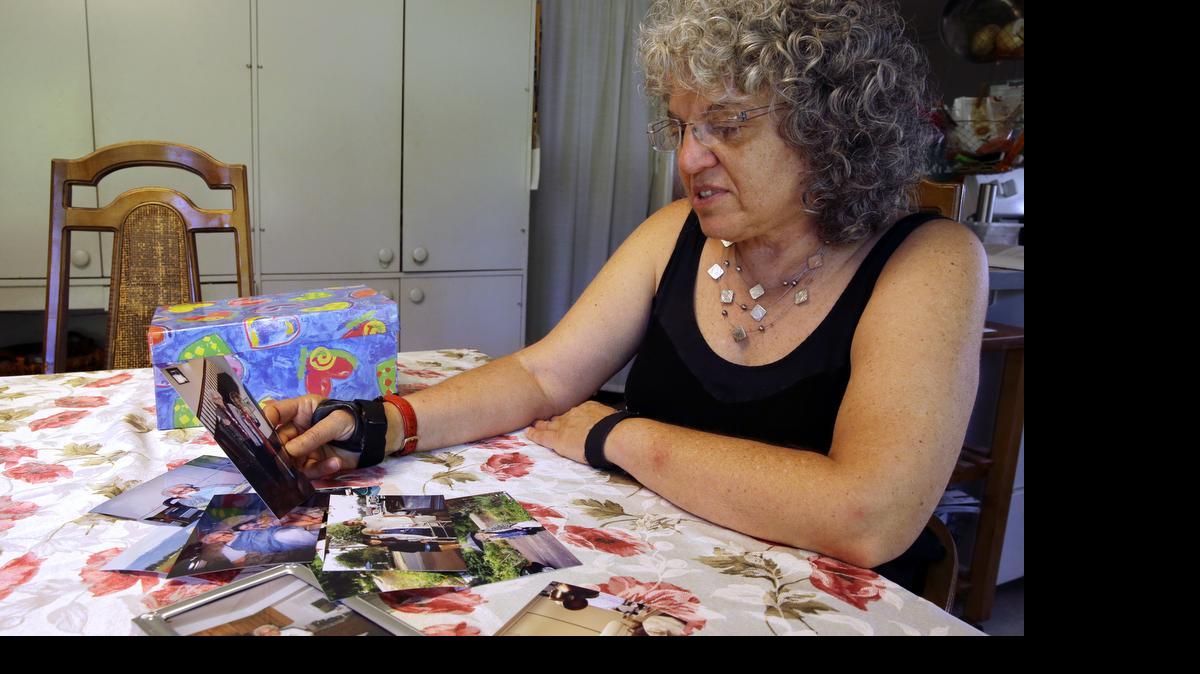 
Roslyn Duffy looks through photos of her late mother, Evelyn Nappa, at her home in Seattle. Duffy had to scramble to find a home willing to take Medicaid payments after her mother was evicted from a Seattle assisted-living facility. The stress and the change of surroundings strained her mother's health, Duffy said, and six weeks after moving, she was dead. 
