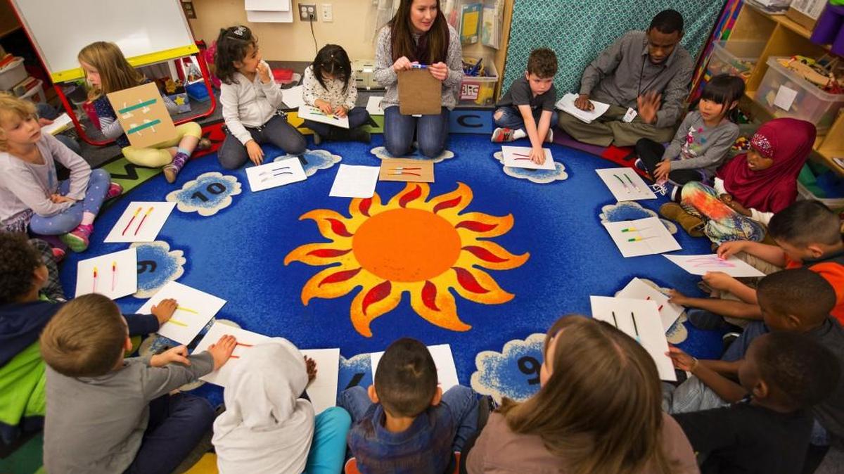
Pre-K teacher Julia Brady uses handmade beads on pipe-cleaner boards with her students during a recent math lesson at South Shore Pre-K School. Math games are used to teach prekindergarteners about math concepts. 
