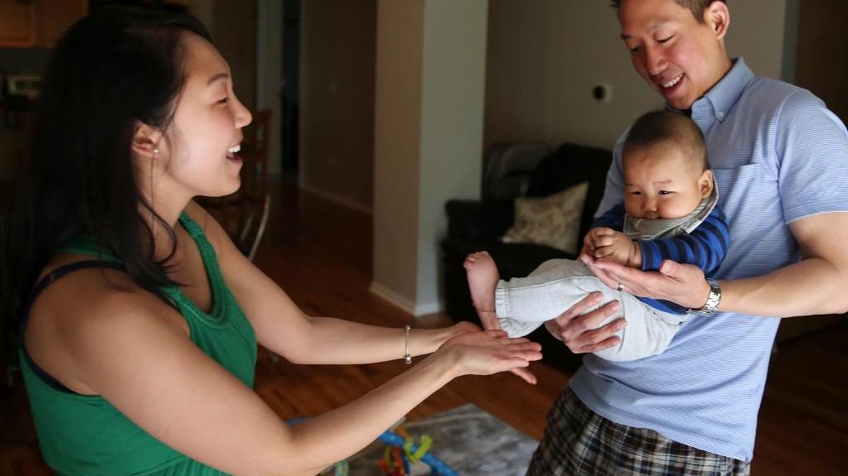 Mike and Haenah Hwang play with their son Evan, 4 months, before putting him down for a nap.