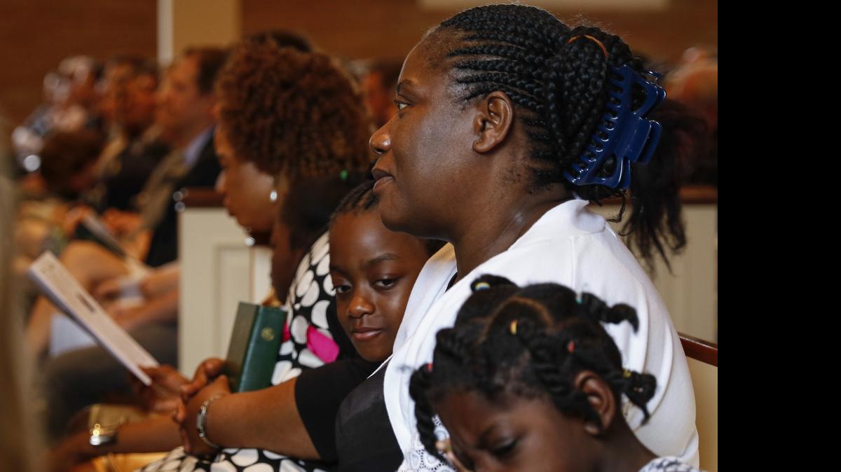 
Louise Troh, center,, the fiancee of Thomas Eric Duncan, sits with her granddaughters Rose Yah, left, 6, and Knowledge Dopoe, 5, at Wilshire Baptist Church in Dallas.
