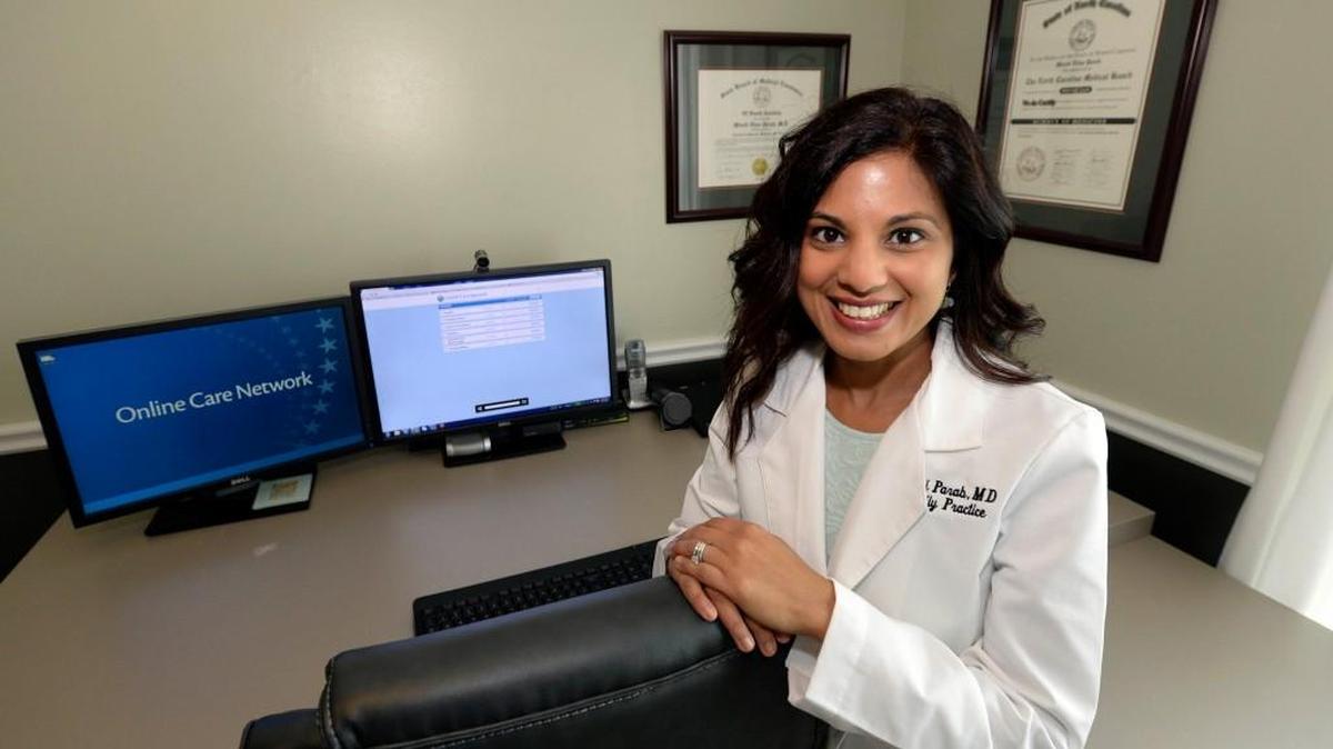 
Dr. Minoti Parab, a telehealth staff physician with Online Care Group, at her home office in Charlotte. Parab practices family medicine, but sees no patients in person. All her telemedicine patient consults are done via the Internet. 
