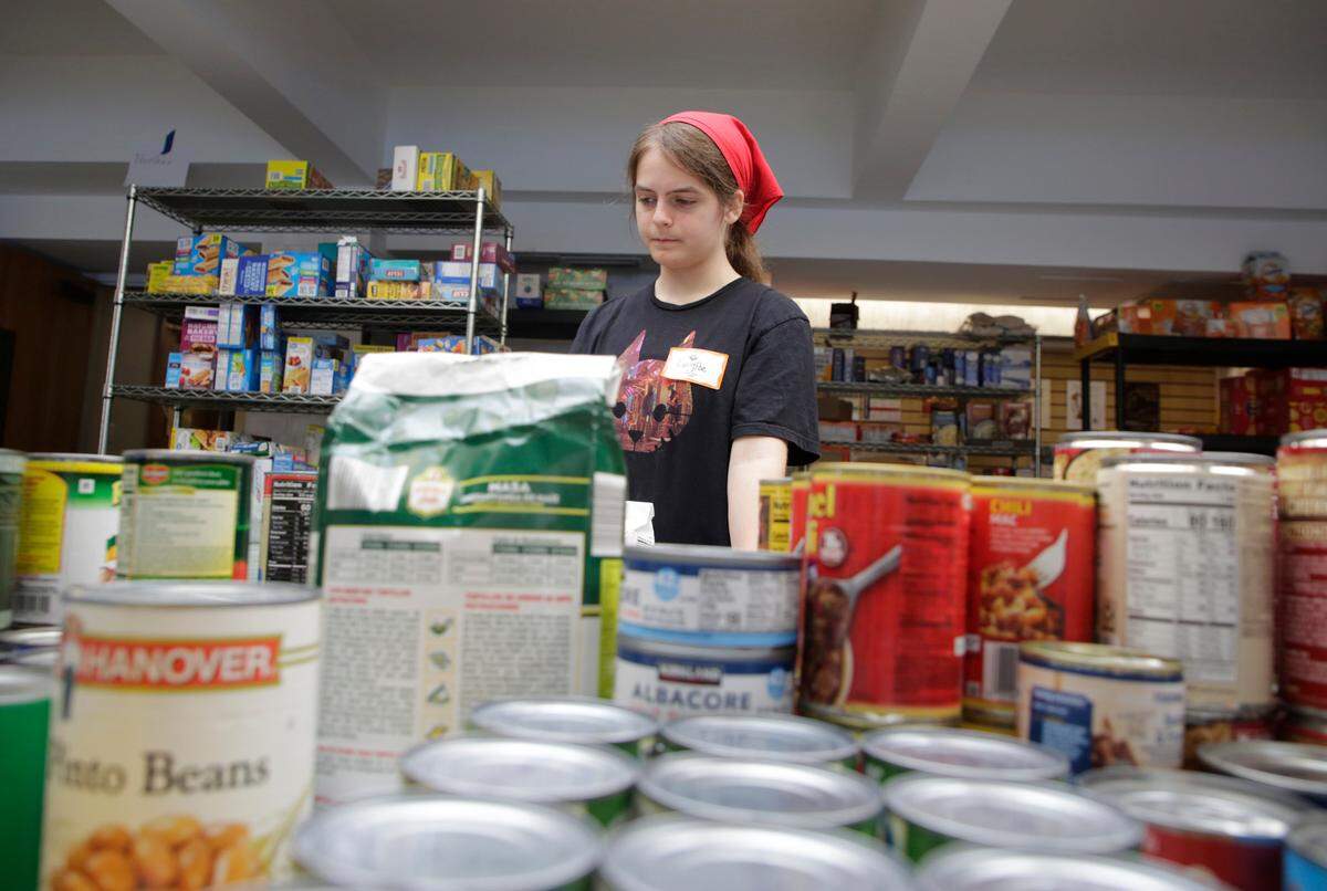 Lucy Poe sorts through canned goods Friday, Oct. 4, 2024 in Black Mountain, N.C.