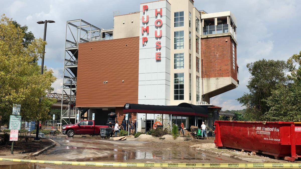Workers clean up the grounds around the Pump House Restaurant in Riverwalk on Monday. The restaurant, which sits next to the Catawba River, flooded when Hurricane Helene caused the river to rise.