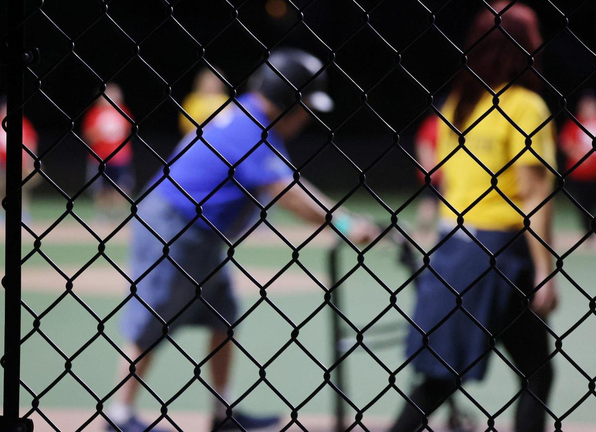 Larry Ferguson, left, makes his way to hit the ball Wednesday at the Miracle League baseball park in Rock Hill.