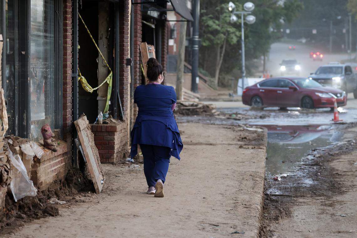 A pedestrian walks in Biltmore Village near downtown Asheville, N.C. Oct. 4, 2024. Biltmore Village was an area that was devastated by heavy flooding due to Tropical Storm Helene.