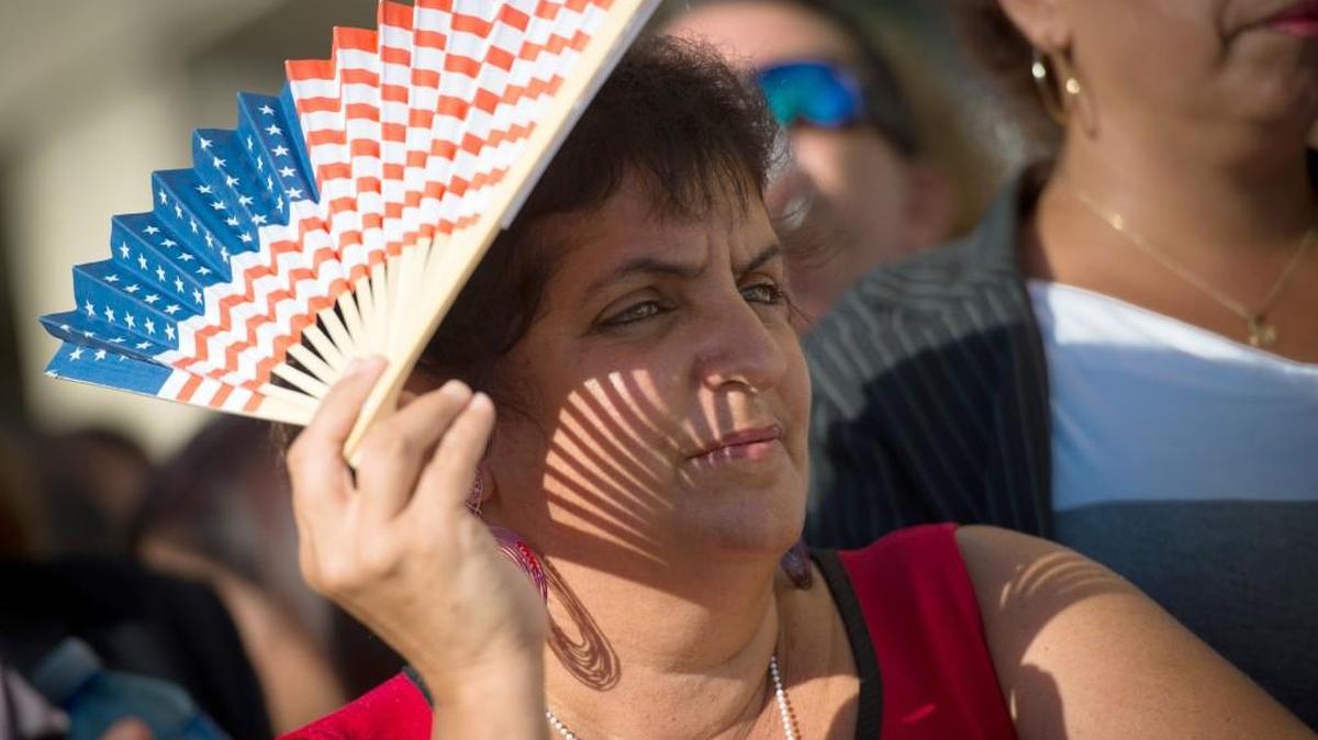 Doris Mosuera, 46, a cook at the U.S. diplomatic mission in Havana, waits to watch the raising of the U.S. flag at the embassy at its official reopening in August. No event in decades shook up Cuba like the announcement last Dec. 17 by presidents Barack Obama and Raul Castro that their countries would begin normalizing long-broken relations, but Cuba is still very much the same country it was a year ago.