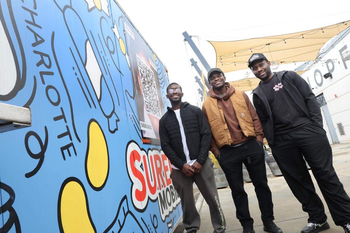 From left, Magloire Lubika, Edric Lutuangu and Joel Lutuangu have a food truck called Surefire at HopFly Brewery near uptown Charlotte. The business owners ran Surefire Neighborhood Market in Rock Hill before it burned last summer.