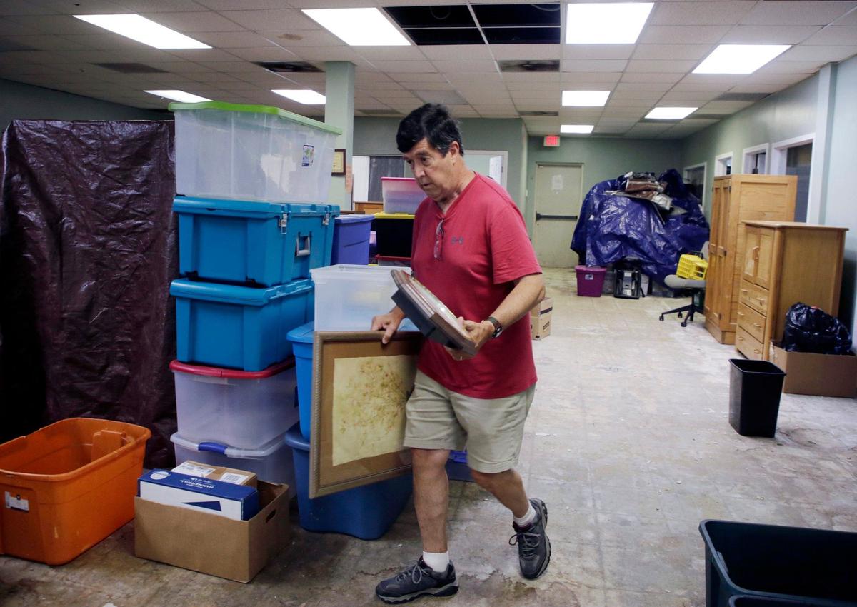 Knights of Columbus volunteer Vince Williams carries a wall hanging to be stored Friday at Family Promise of York County.