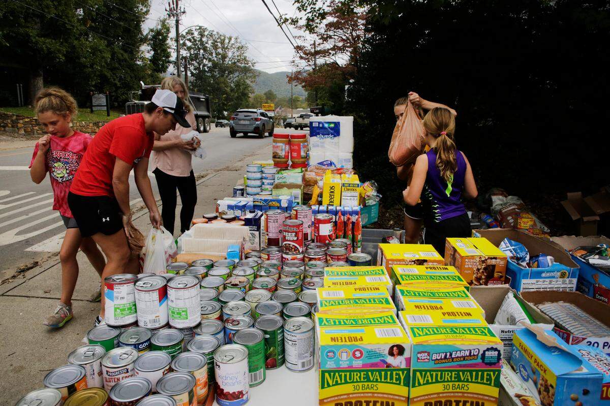 Volunteers load bags of groceries at a pop-up food bank in Swannanoah, N.C. on Friday.