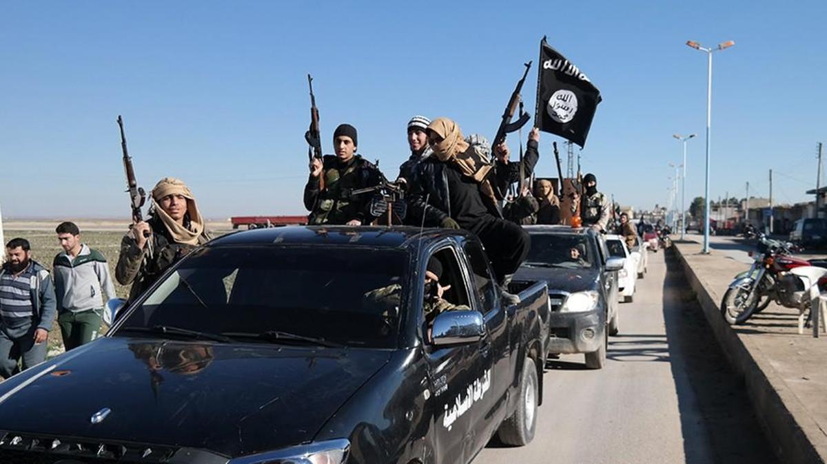 Islamic State militants pass by a convoy in Tel Abyad, northeast Syria. The Islamic State rakes in up to $50 million a month from selling crude from oilfields under its control in Iraq and Syria, part of a well-run oil industry that U.S. diplomacy and airstrikes have so far failed to shut down, according to Iraqi intelligence and U.S. officials.