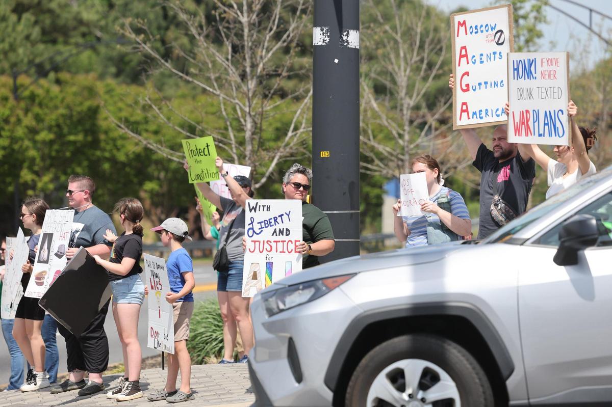 Protestors hold signs Saturday at the York County Rising demonstration in downtown Rock Hill.