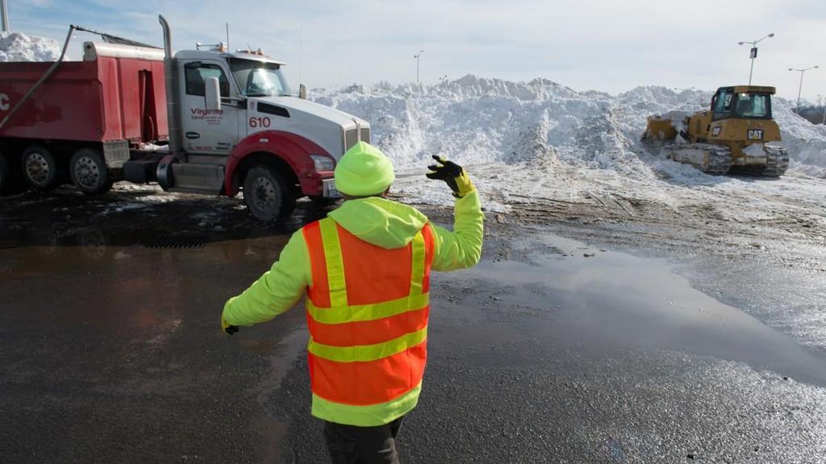Trucks filled with snow from Washington, D.C., streets are dumped in huge piles in the parking lot at RFK Stadium on Monday.