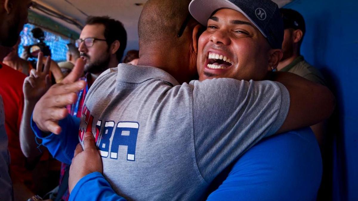 St. Louis Cardinals player Brayan Pena, from Cuba, embraces a former colleague before giving a baseball clinic to children in Havana, Cuba, on Wednesday.