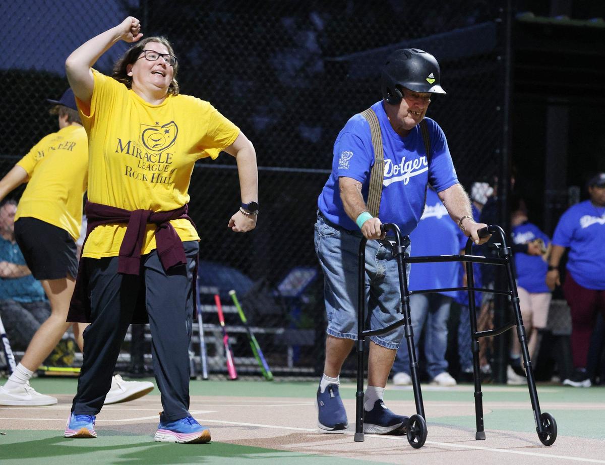 Larry Ferguson, 80, makes his way to first base after hitting the baseball Wednesday at the Miracle League game in Rock Hill. Cheering him on is Melissa Inzerillo.