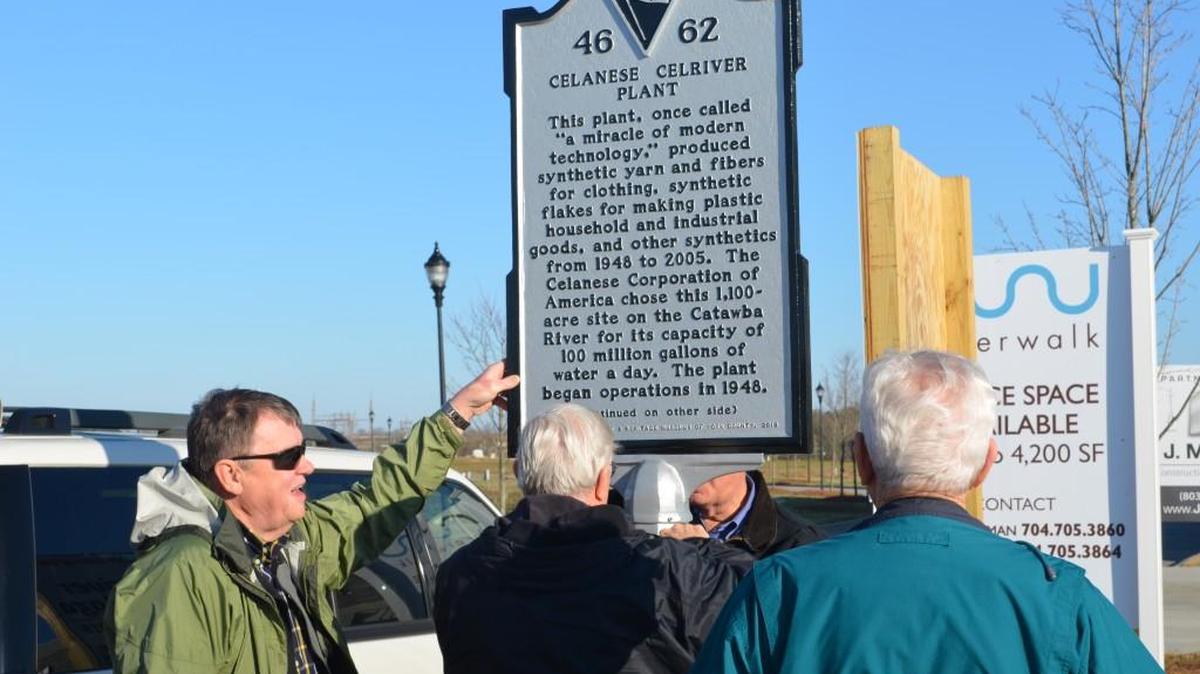 Ed Ewald, far left, provides a steady hand as the two-side marker explaining the history of the Celanese fiber plant is installed Friday in Riverwalk. The marker is part of the Celriver Legacy Project to preserve the history of the plant which once was one of the major employers in Rock Hill.