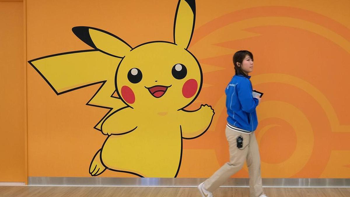 An employee walks past a wall featuring the Pikachu character at the Pokemon Center Mega Tokyo store in Tokyo.