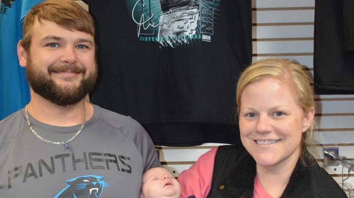 Tony Porter, left, with his wife Barrie and daughter Nellie Blu, shop for Panthers’ gear Thursday. They were hoping to find something for Nellie Blu, who at five weeks old is already a Panthers’ fan, they said.