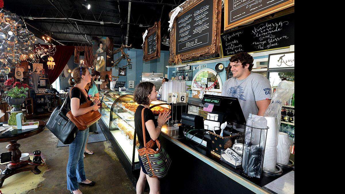 ABOVE:  Customer Sarah Flohr, middle, orders from Sam Bramlett at the original Amelie's location in NoDa.  Right:  The decor there is French kitsch.