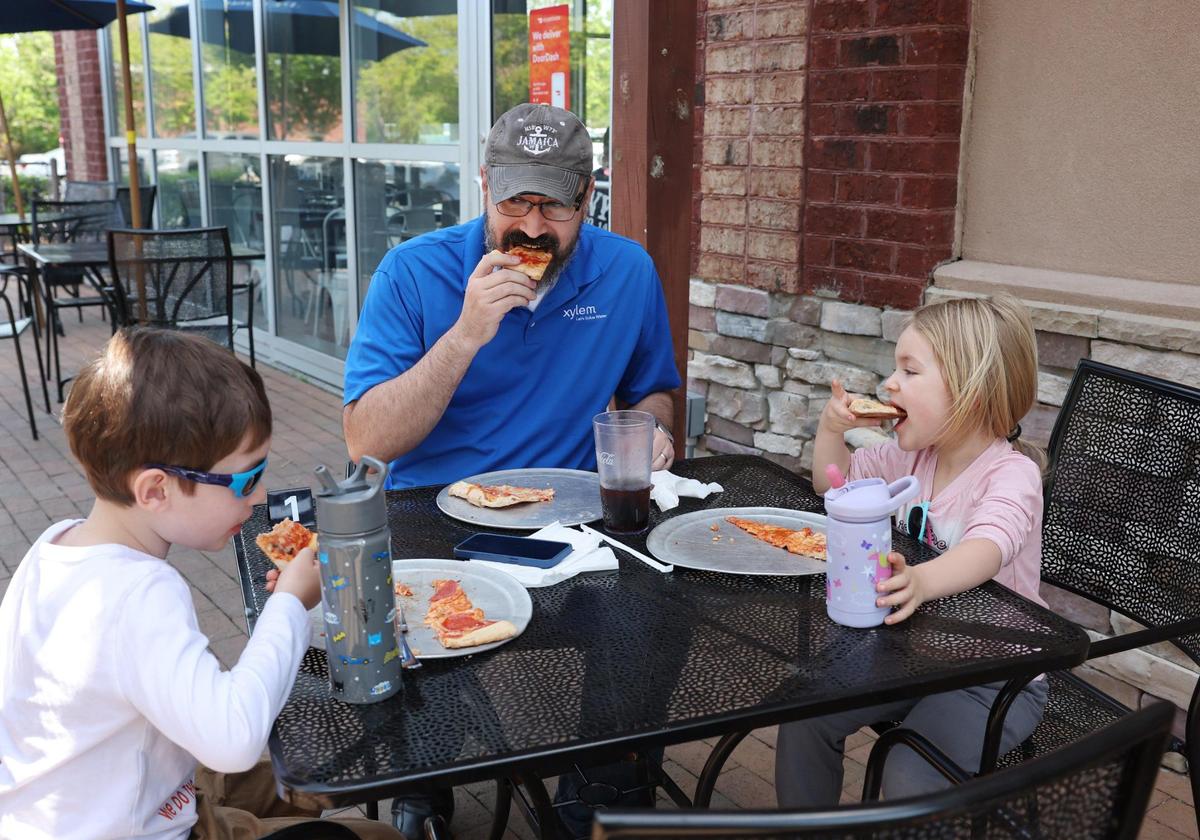 From left, Emerick Stott, 6, Gerald Stott and Adeline Stott, 3, eat pizza at Napoli’s Pizzaria in Tega Cay on Friday.