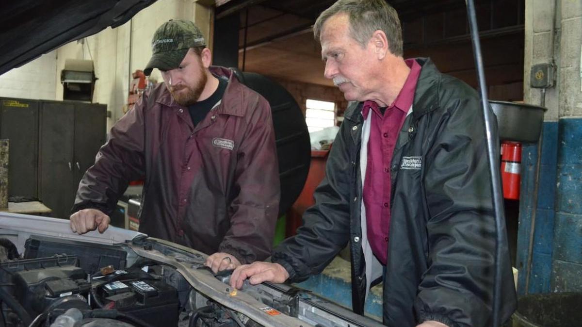 Zach Yonce, left, and his father, Simmie, listen to a car brought in for service last week at Yonce Motor & Tire Company on Cherry Road.