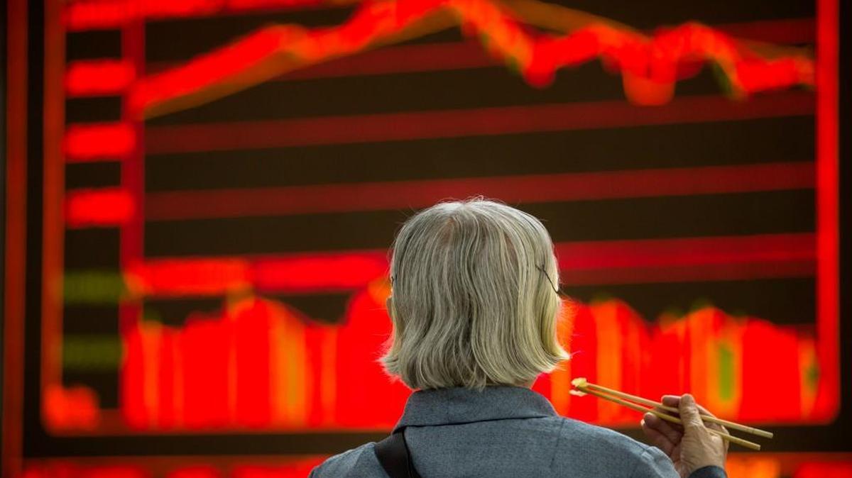 
A Chinese investor eats lunch as she monitors stock prices at a brokerage house in Beijing.
