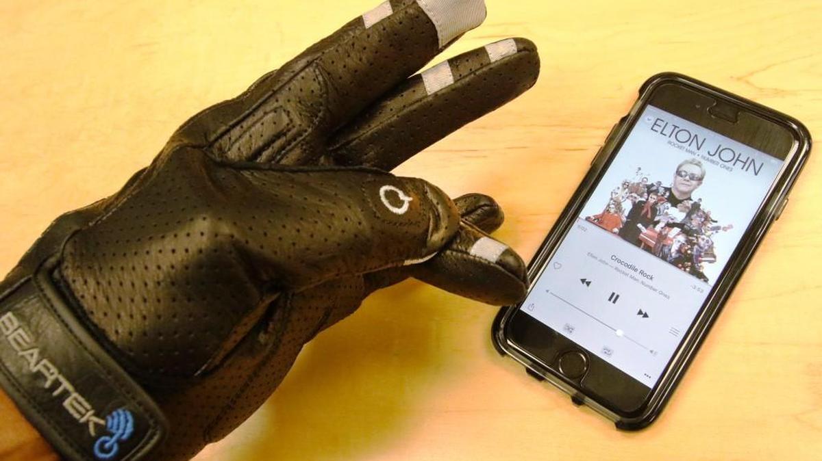 Blue Infusion Technologies CEO Tarik Rodgers demonstrates the BearTek glove. By touching certain areas on the fingers, the glove can control several functions on the phone via bluetooth connection.