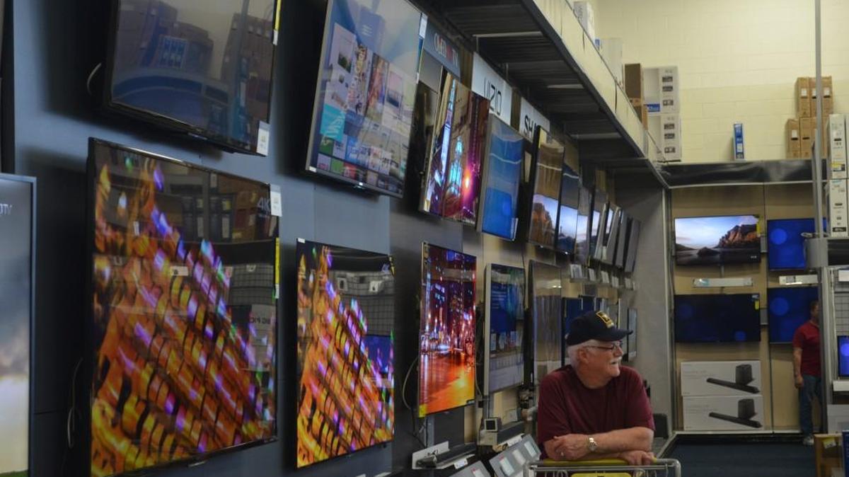 David Walker waits for some help to check out in front of a variety of big-screen televisions at Best Buy in Rock Hill.