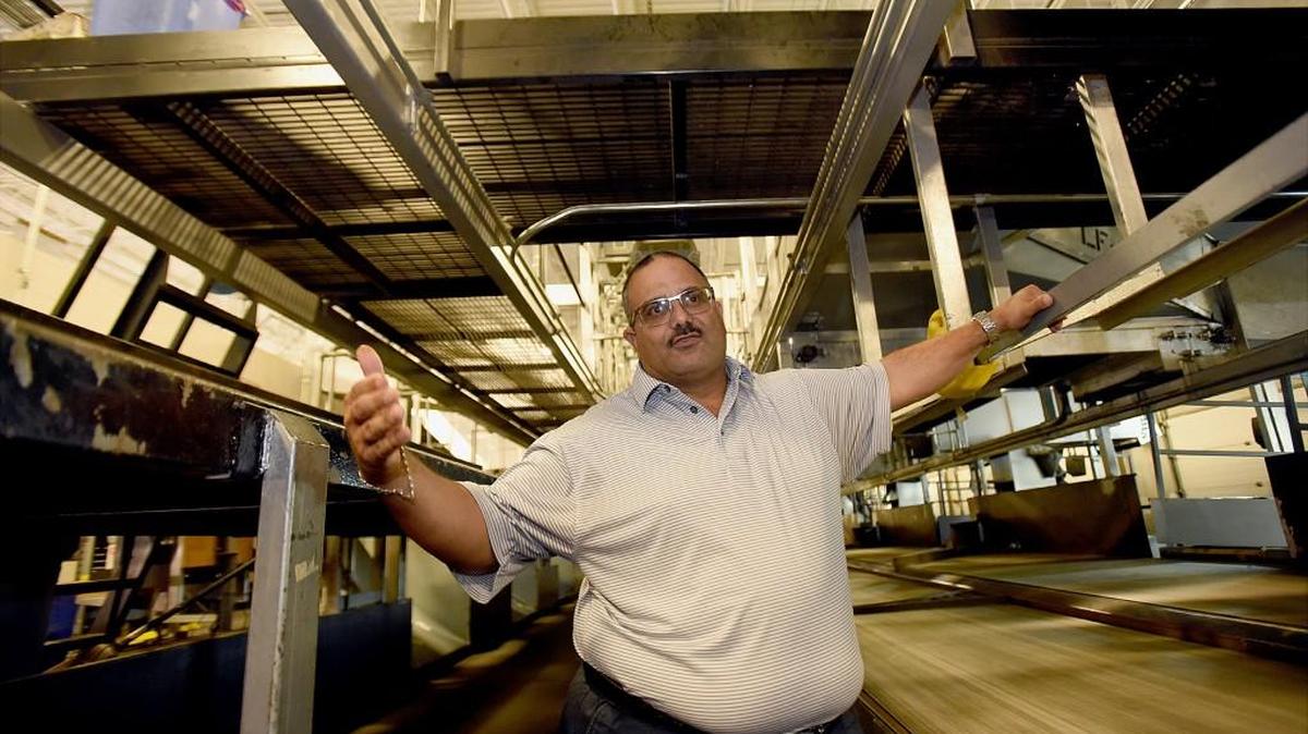 Surrounded by a maze of sorting conveyors going in every direction, Walt DeMase explains the package sorting process at the UPS depot in Jackson, Pa.