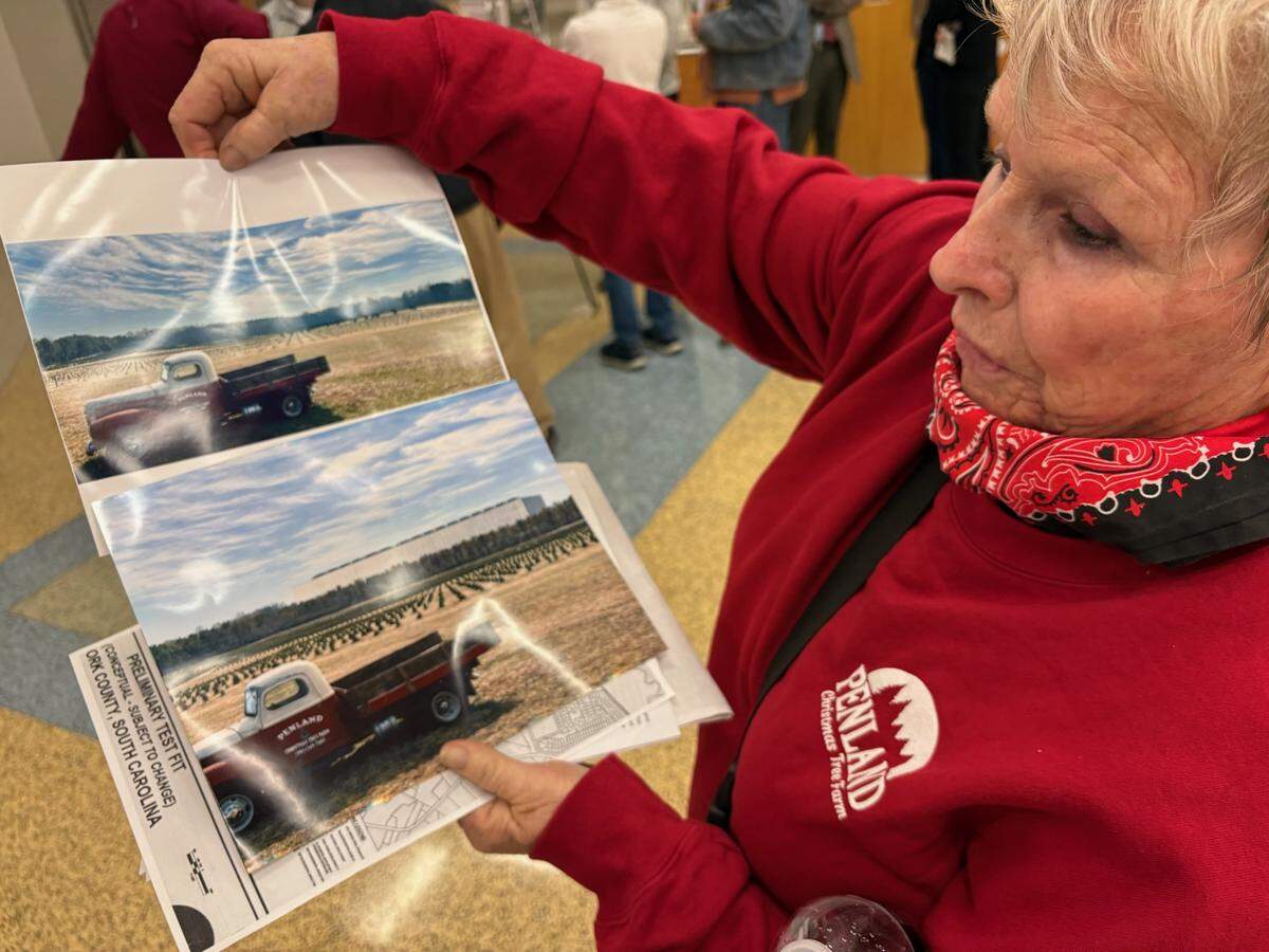 Judy Penland compares images of her family Christmas tree farm with a rendering of the same site with a QTS data center beside it, at a February public meeting about the data center. Residents want York County to change the way it approves future data centers.