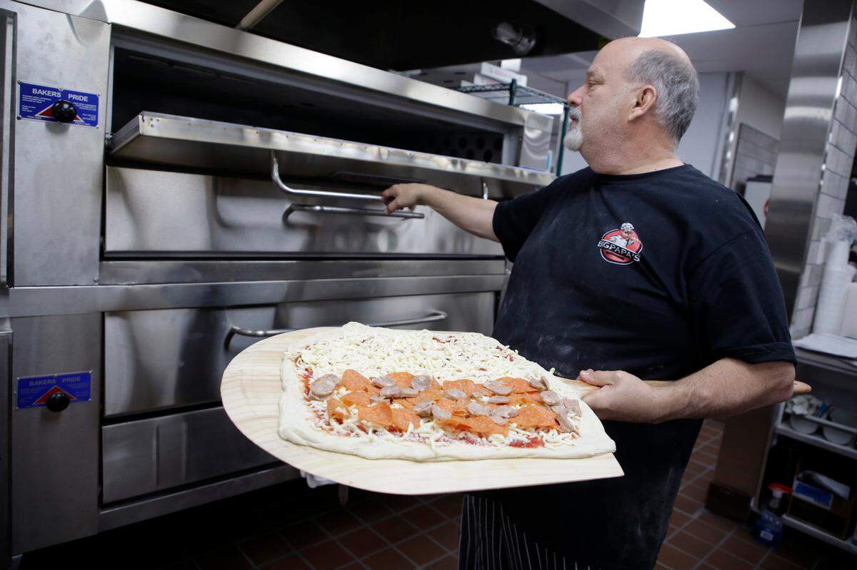 Jerry Simonetti prepares to put a pizza in the oven Tuesday at Big Papa’s in Lake Wylie. The restaurant opens April 1.