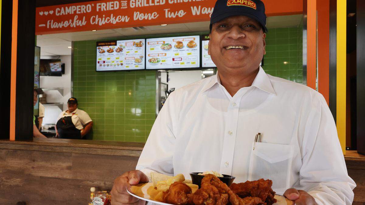 Rajesh Chauhan holds a plate of fried chicken Tuesday at the new Pollo Campero in Rock Hill.