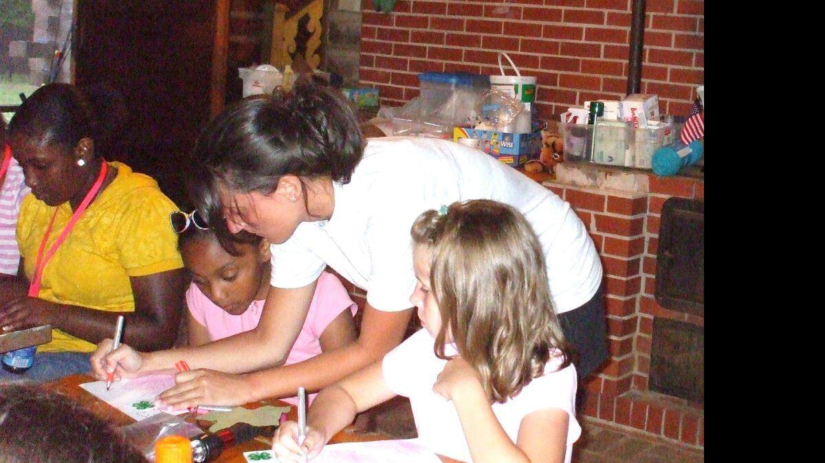 
An intern from Winthrop works with girls at 4-H Camp Tree Tops before it closed several years ago. A Charlotte homebuilder has bought the property and plans to build 835 homes there.
