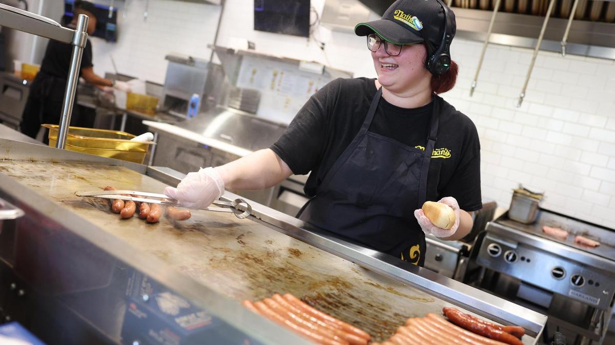 Kelsi Crisp grills hot dogs Friday at Nathan’s Famous on Celanese Road in Rock Hill. York County has more than two dozen restaurants that opened this spring, or have announced plans to open.