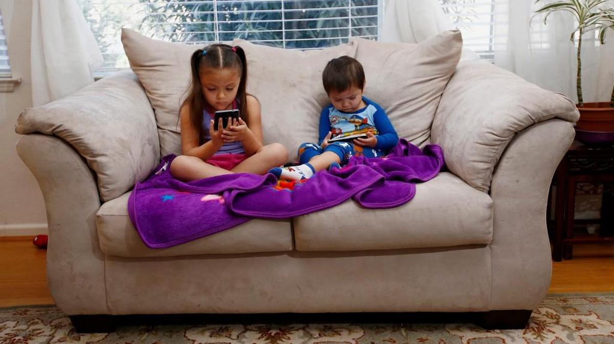 Juliana Sanchez, 5, and her brother, Francisco Sanchez Jr., 2, watch children’s programming on YouTube on their parent’s cellphones. Watching digital video on hand-held devices is the new normal for tots, tweens and teens.