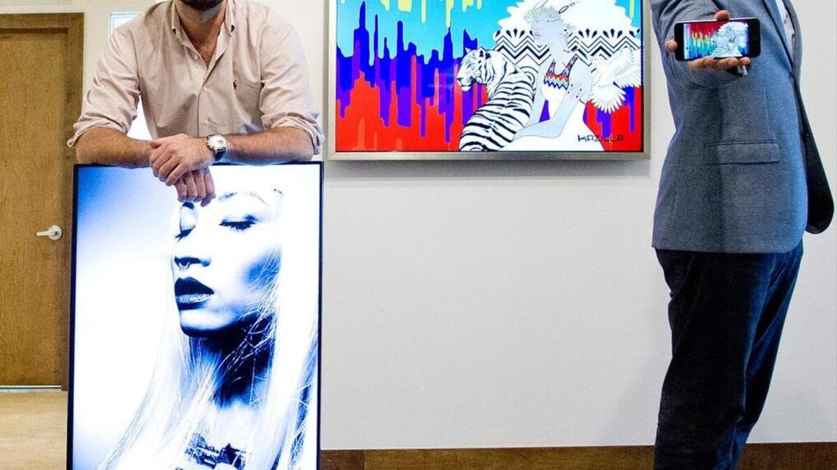 Blackdove, a Miami-based tech startup, offers a global platform and marketplace for digital motion art. Founders Tito Gaudenzi, left, and Marc Billings are shown with samples of the art. On the wall is “Urban Decay” by Kazilla; Gaudenzi holds “whtEyesRoses” by jon Cates.