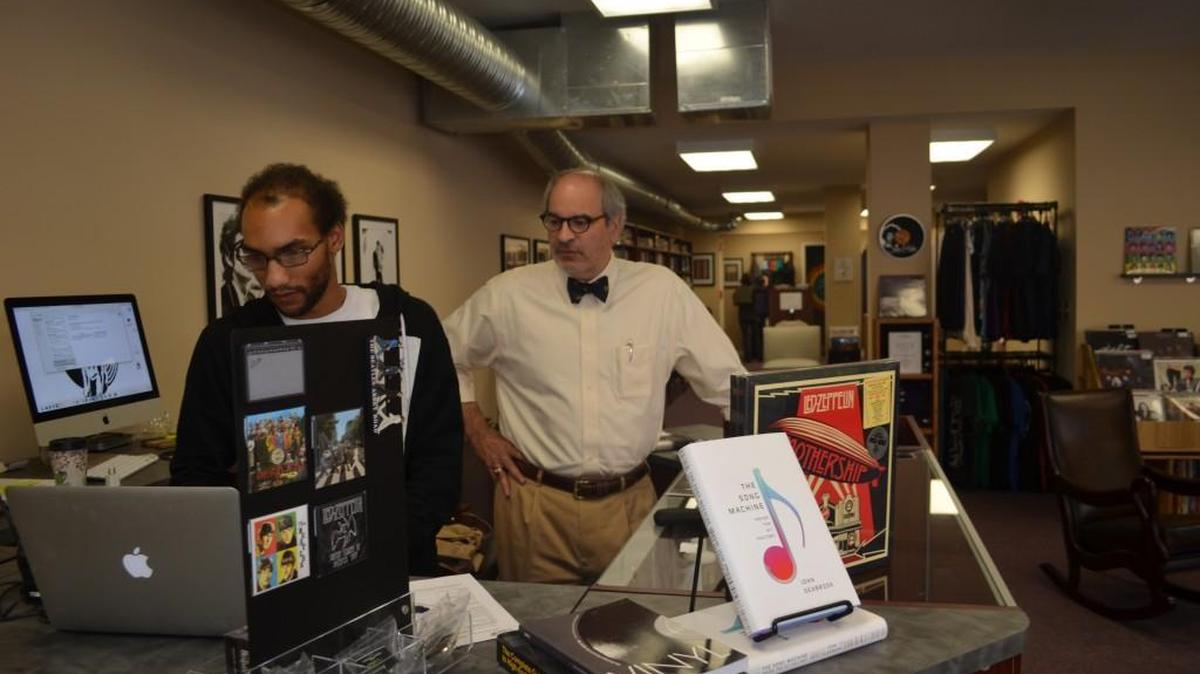 Vinny Nigro looks up prices for new vinyl albums while dad Paul watches at The Newsstand Records & Books shop in downtown Rock Hill.