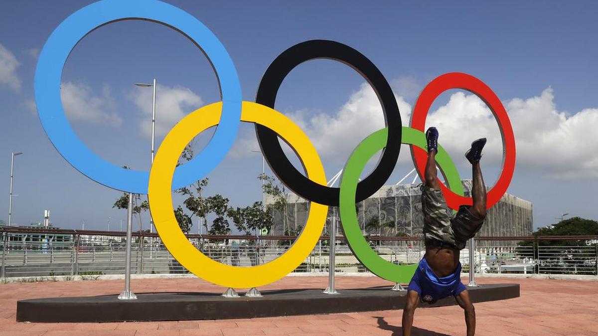 A man performs a handstand in front of the Olympic rings before the 2016 Summer Olympics in Rio de Janeiro, Brazil.