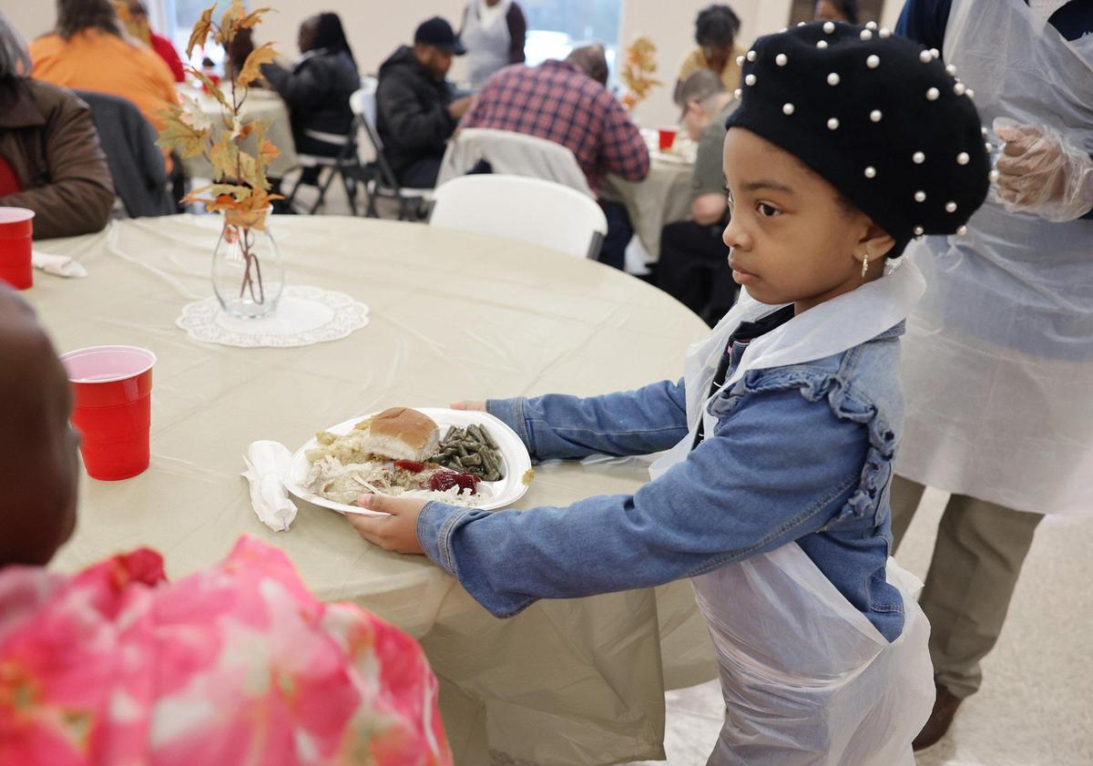 6-year-old Journee Gore serves a plate Tuesday at a pre-Thanksgiving meal at Cedar Grove Baptist Church in Chester.