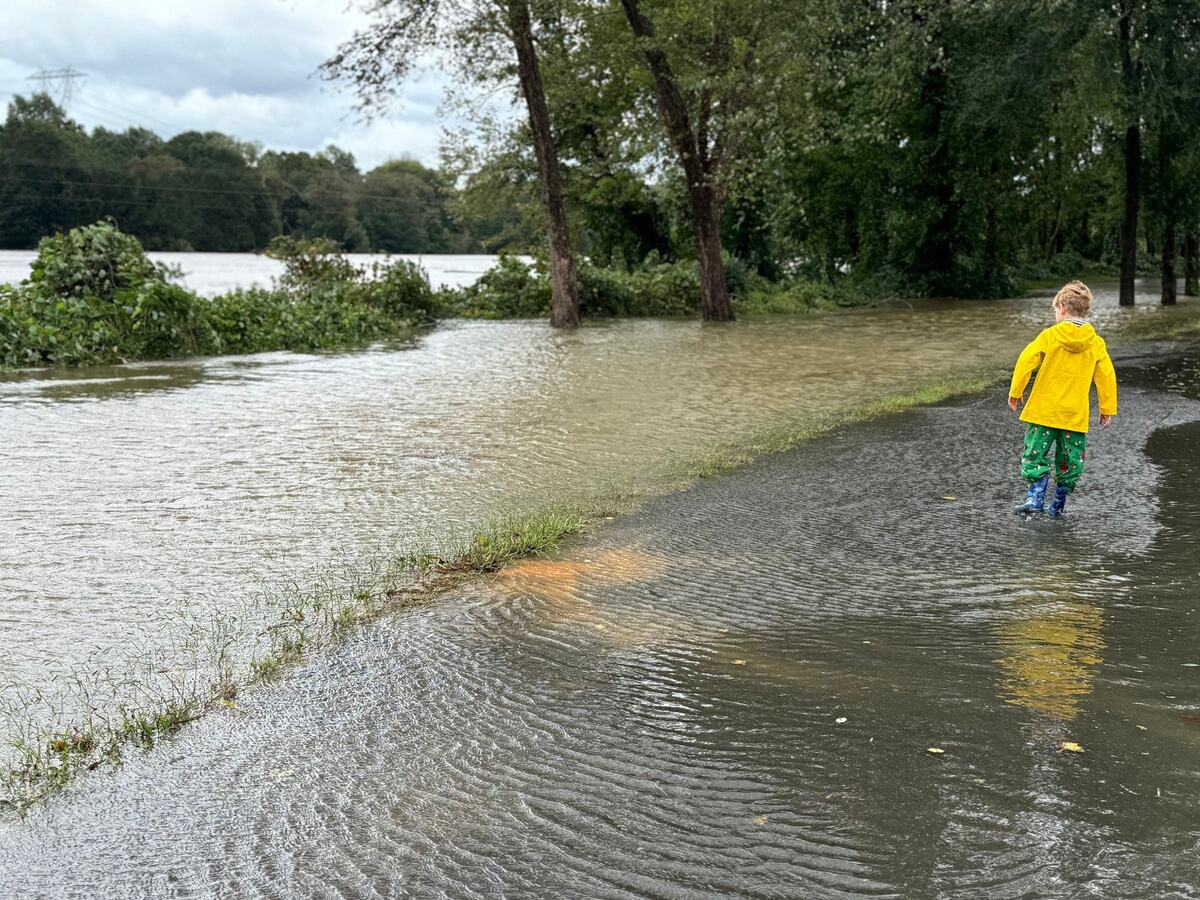 7-year-old Harlan Culberson walks along a flooded path beside the Catawba River Friday as the river overflowed its banks.