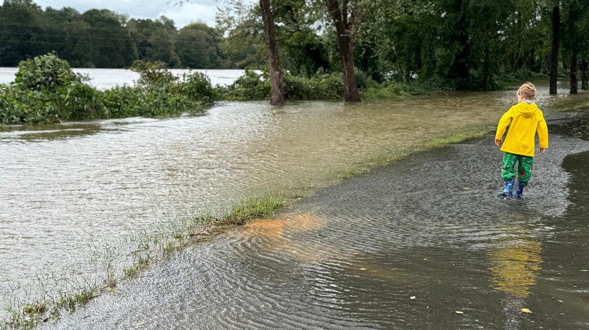 7-year-old Harlan Culberson walks along a flooded path beside the Catawba River Friday as the river overflowed its banks.