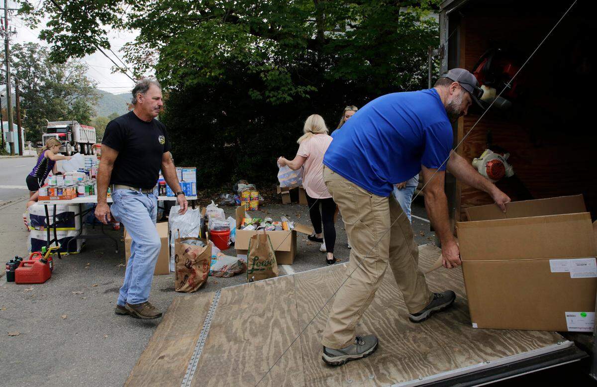 Volunteers load unload groceries at a pop-up food bank in Swannanoa, N.C. on Friday.