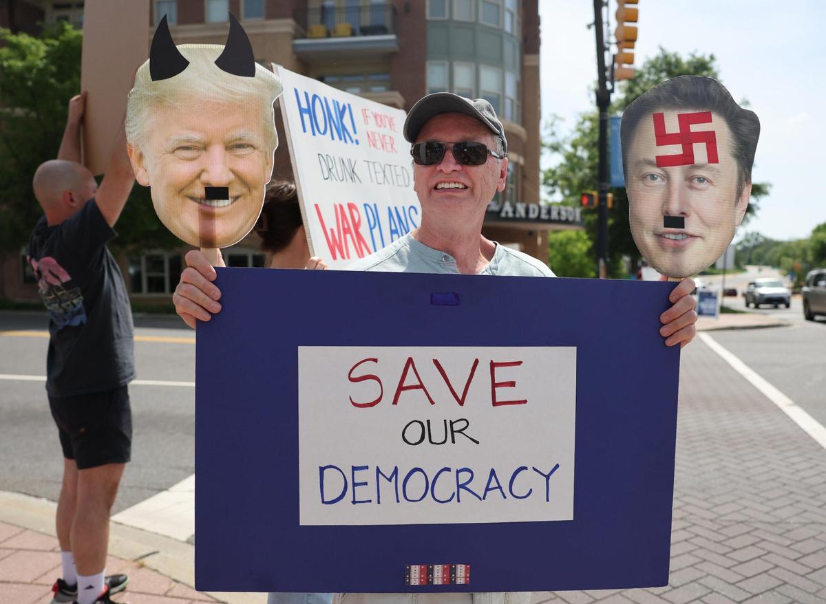 A protestor holds an anti-Trump and Musk sign Saturday at the York County Rising demonstration in downtown Rock Hill.