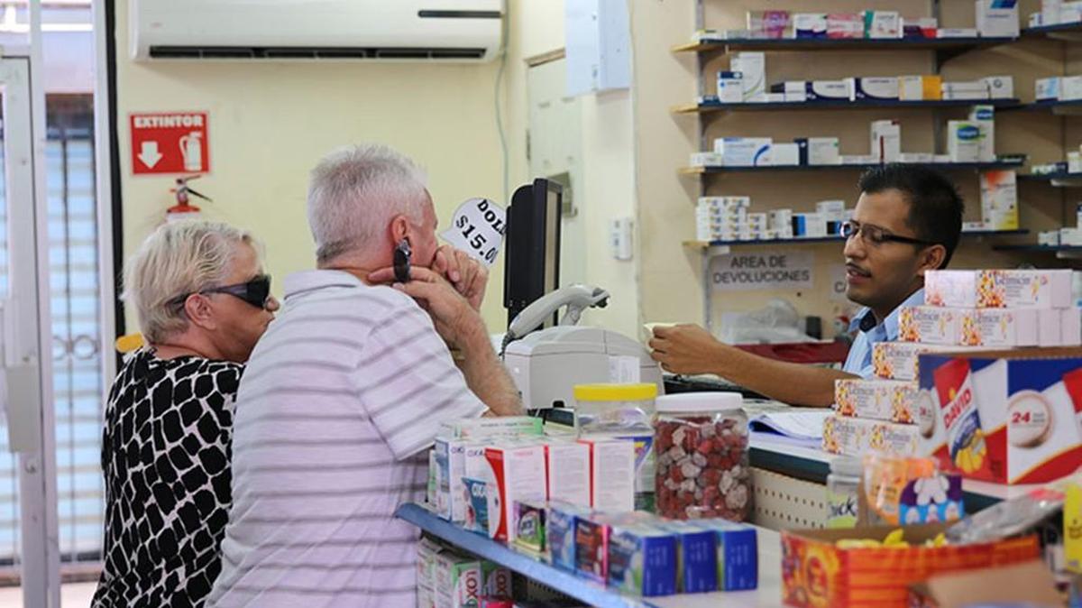 Crihstian Juarez Romero helps two Americans shopping at Farmacias San Jorge in Nogales.