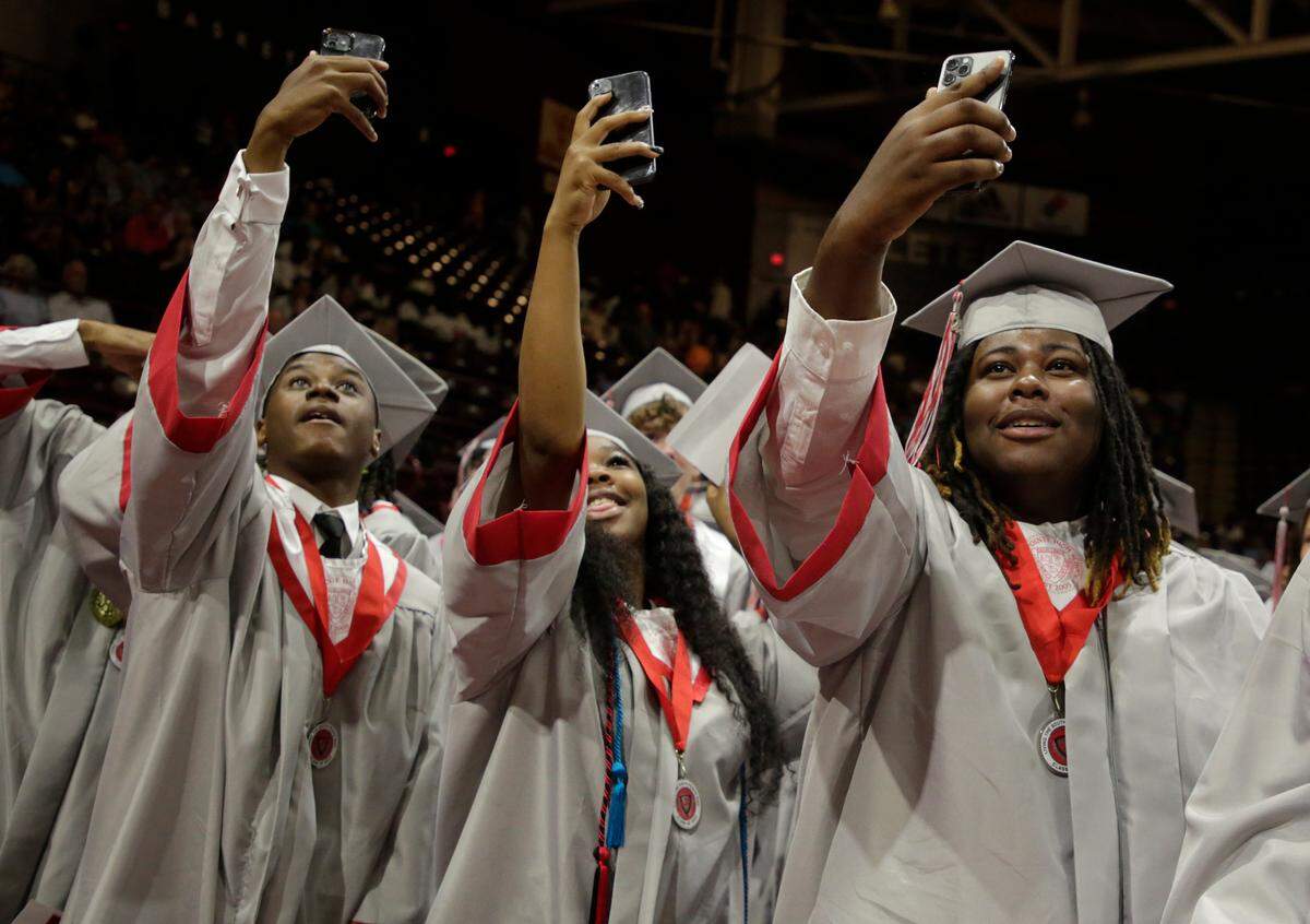 South Pointe High School graduates take selfies at the close of commencement this spring at the Winthrop Coliseum. The Rock Hill School District set a policy last year that other districts will see this coming year, limiting cell phones during the school day.